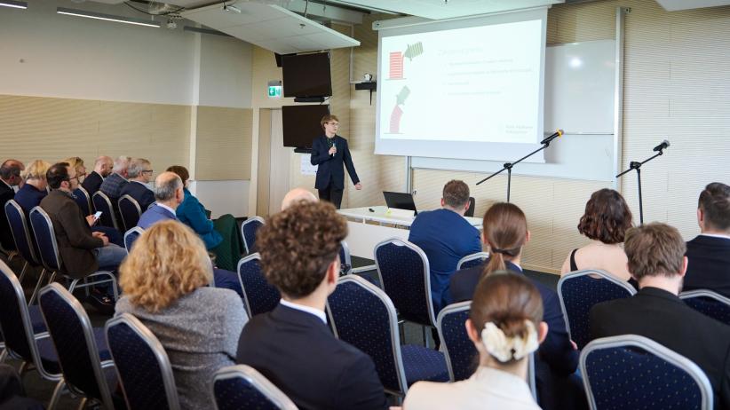 Na zdjęciu widoczna jest publiczność i osoba prezentująca.
