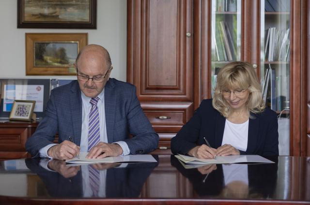Zdjęcie przedstawia podpisywanie porozumienia przez Prorektor ds. Filii w Płocku - dr hab. inż. Renatę Walczak, prof. uczelni oraz Prezesa Zarządu AGAT S.A. -  Zbigniewa Winkiela